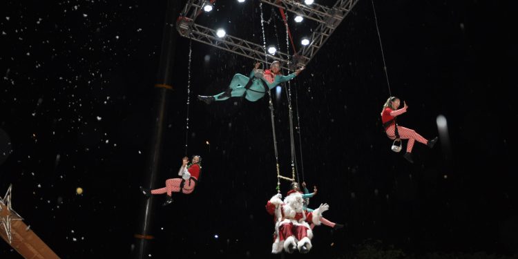 Papai Noel chegou, em meio a neve artificial, suspenso por um guindaste de 30 metros de altura